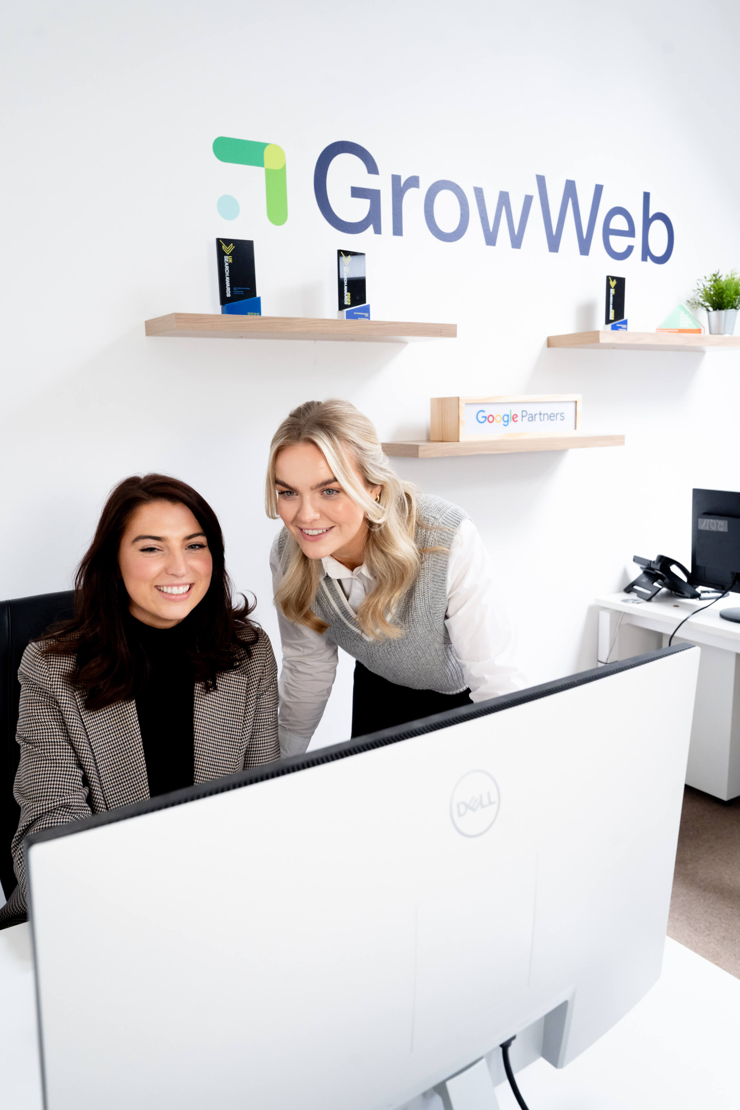 Two members of the GrowWeb team looking at a computer.