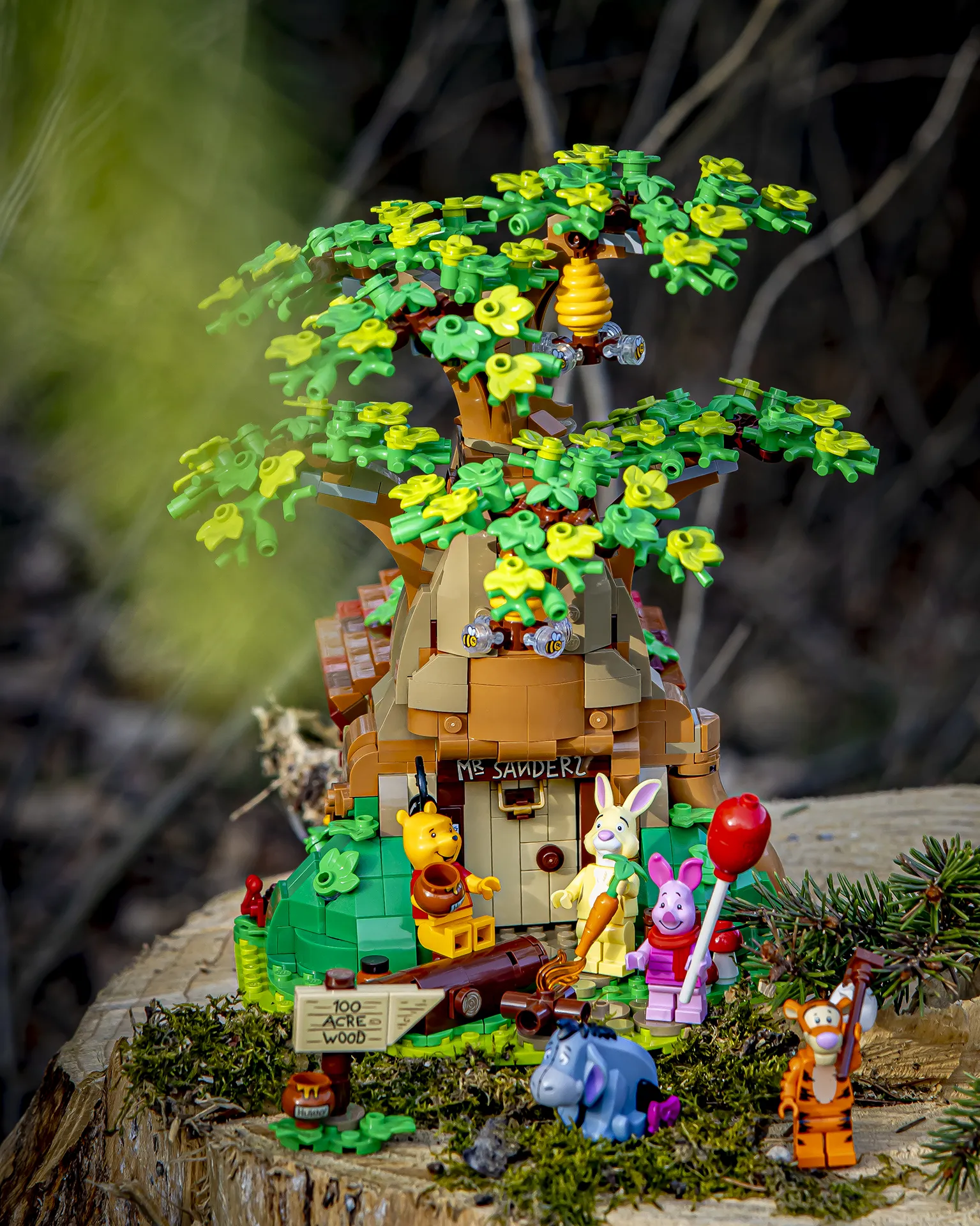 LEGO-modell av Ole Brumms hus med figurer av Ole Brumm og alle hans venner plassert ute i skogen