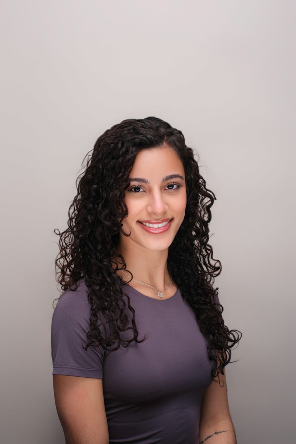 Professional headshot of a woman with curly hair