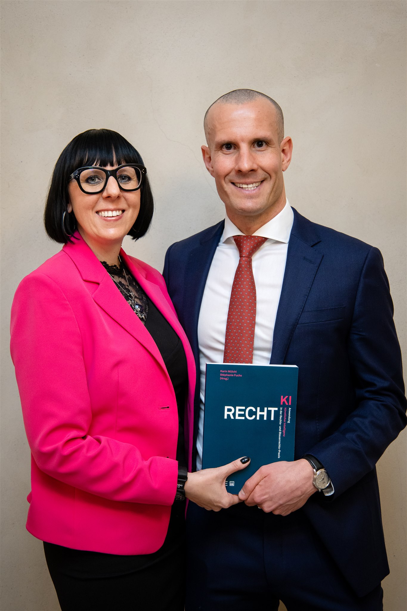 Author posing with guest holding the Recht KI book at book launch in Zurich