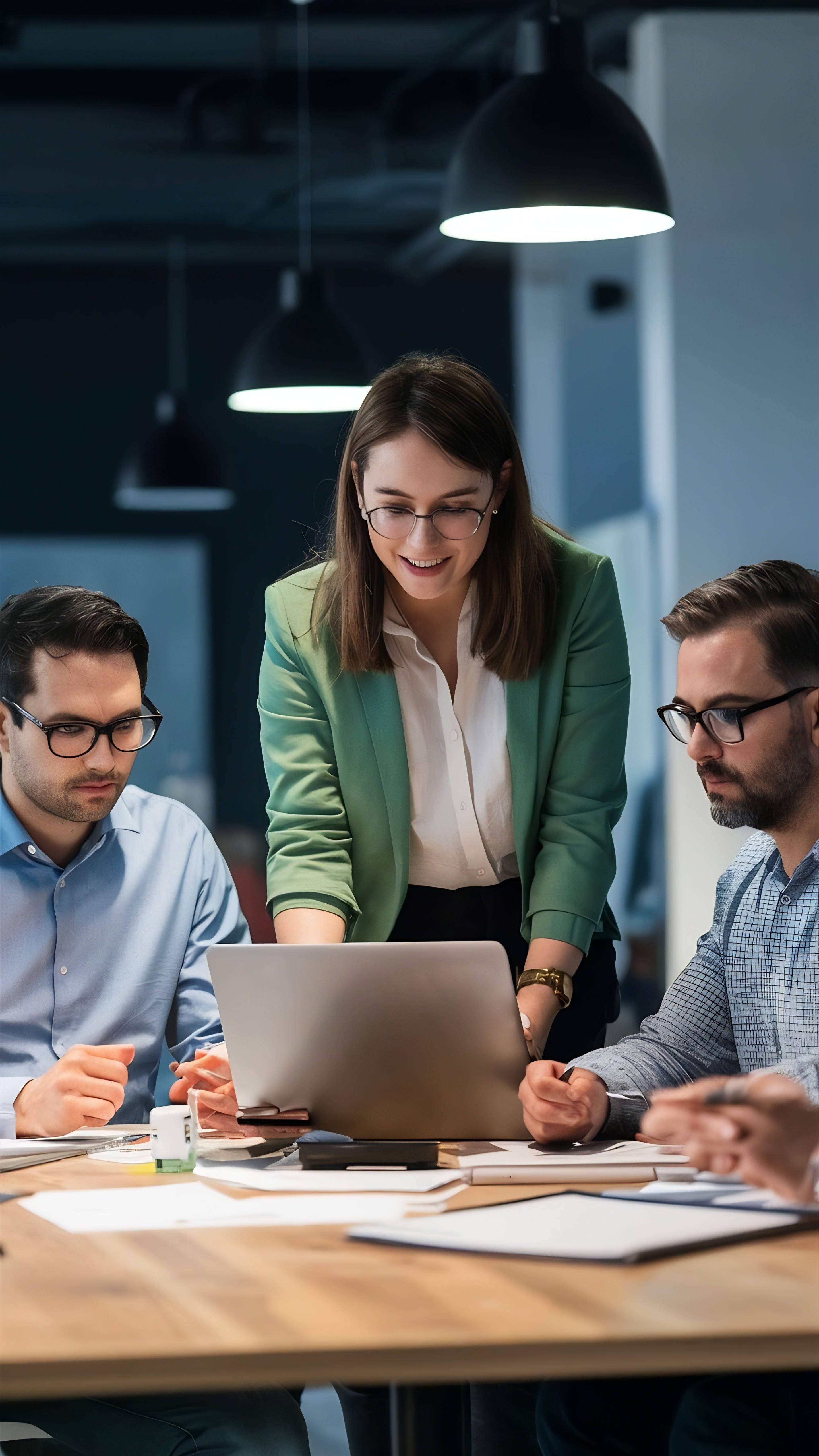 three men sitting while using laptops and watching man beside whiteboard