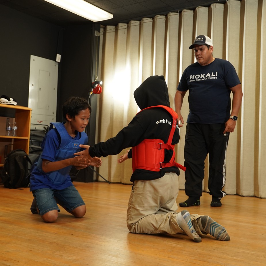 Certified instructor leading elementary students in beginner karate training session