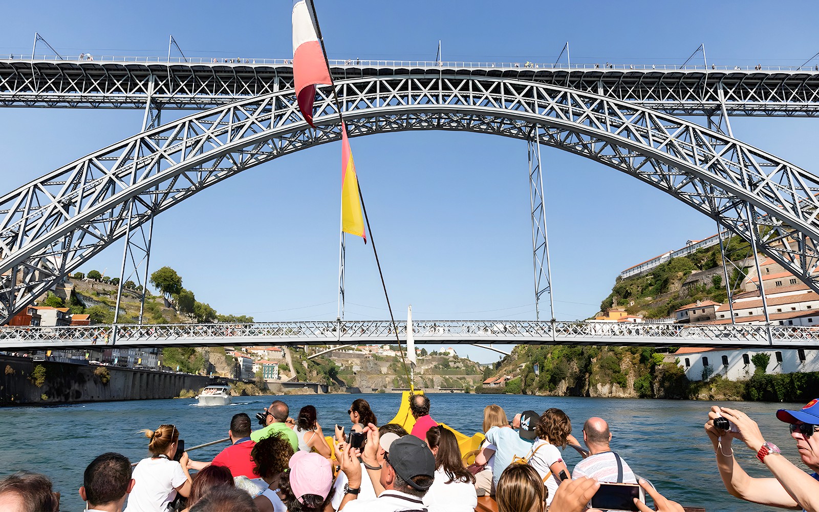 Utasok a Douro folyón hajózva tekintik meg Porto ikonikus hídjait.