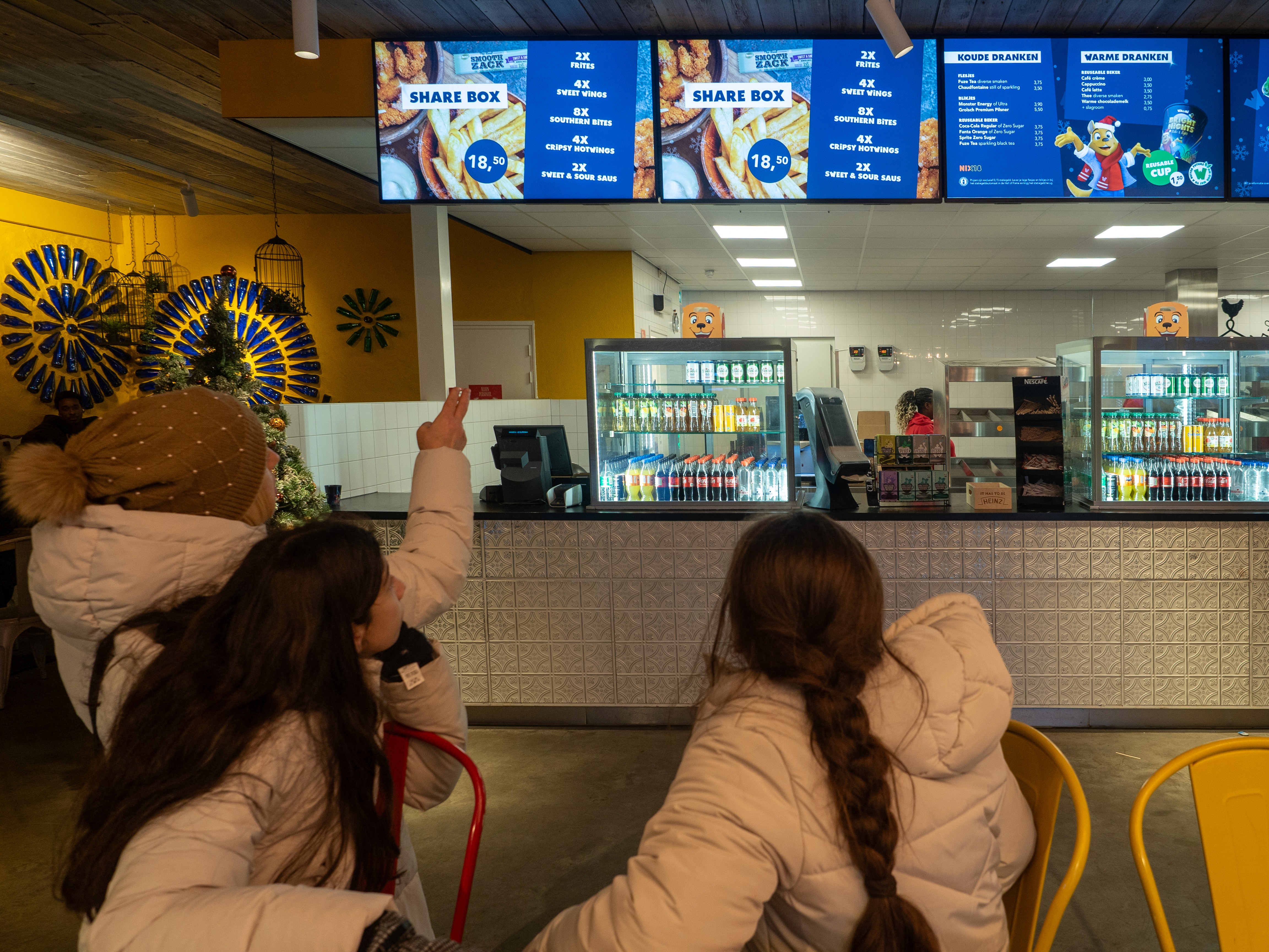 People engaging with a digital signage menu board