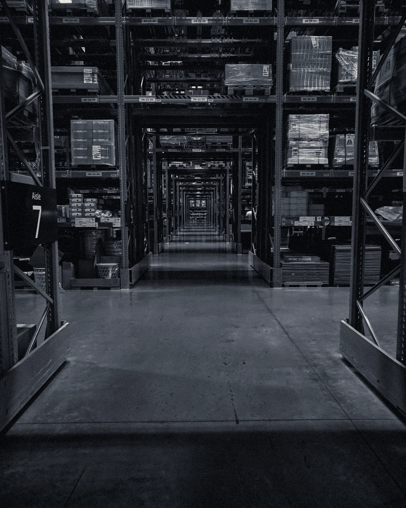 A long warehouse aisle at night