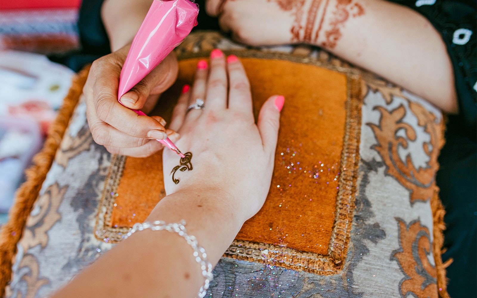 Application de henné sur une main lors d'un safari dans le désert d'Abu Dhabi pendant une expérience.