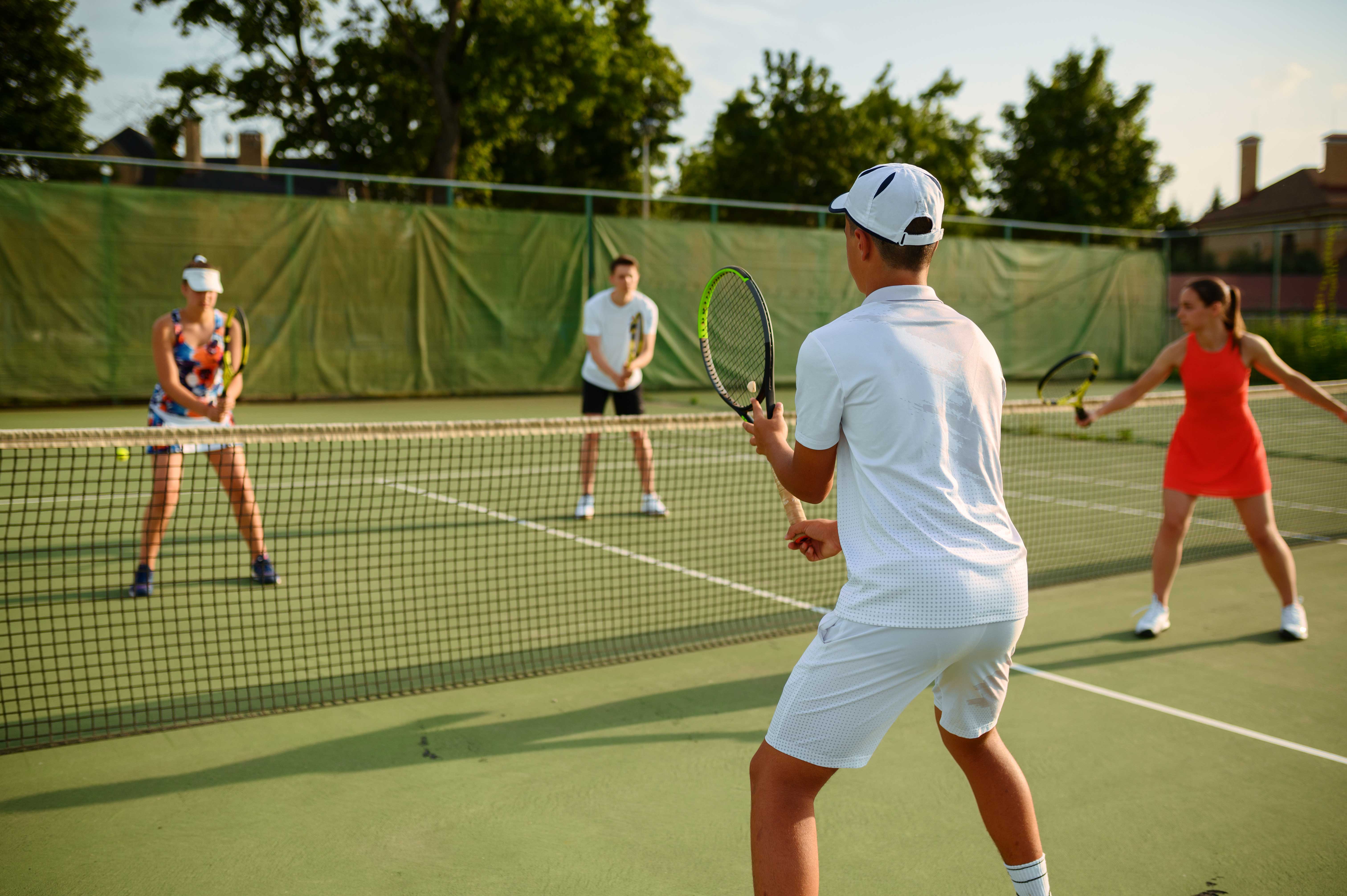 Tennis players on a court in a parks and recreation program managed with TeamLinkt and Amilia