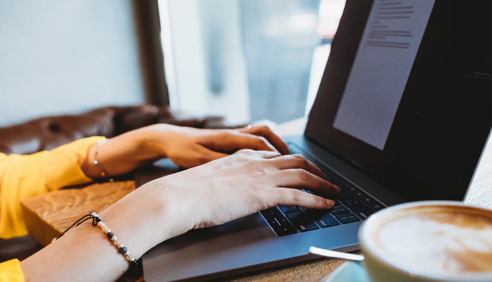 Woman's hands typing on a laptop