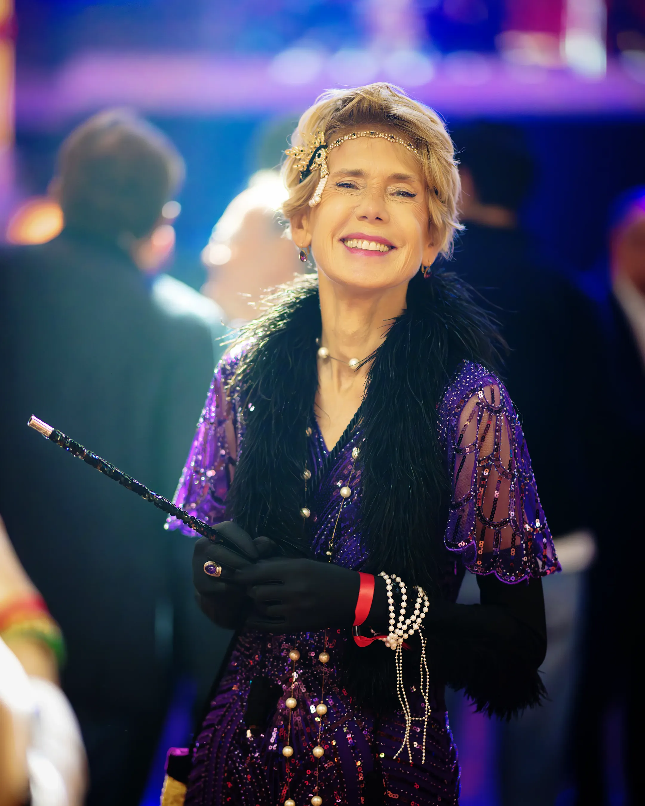 Portrait d’une participante en tenue années 30 souriante lors d’une soirée de gala élégante
