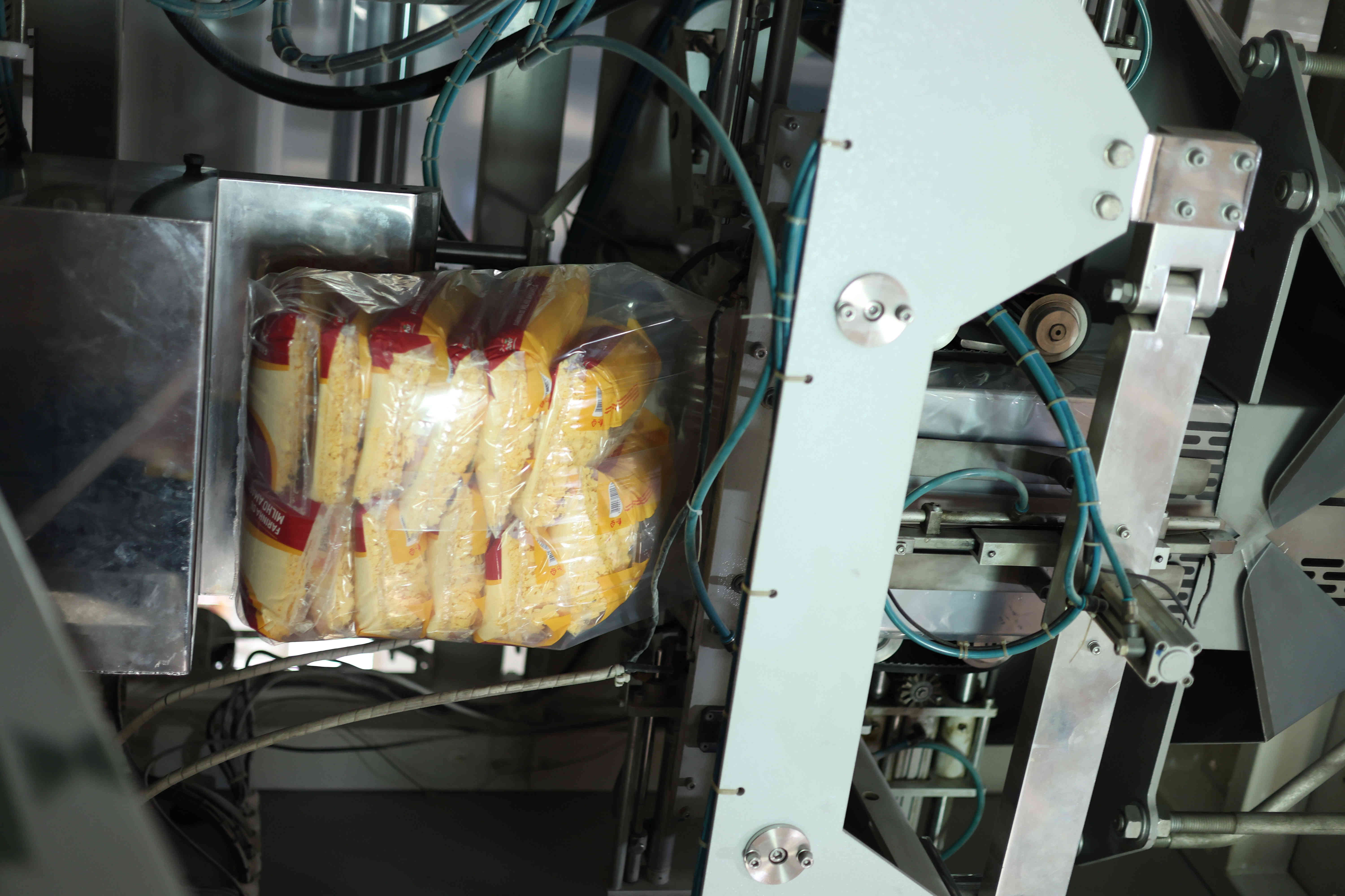 Embaladora automática selando sacos de farinha de milho em linha de produção industrial