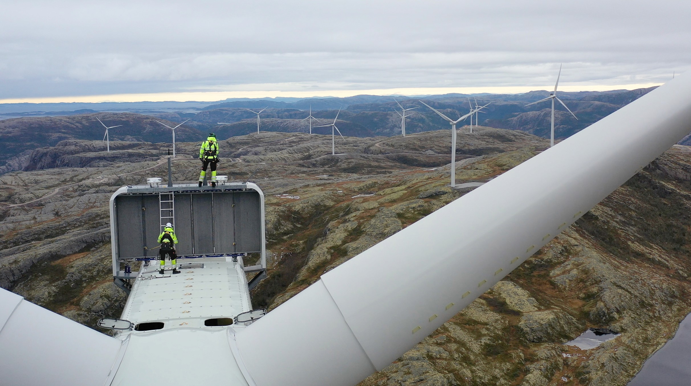 To vindteknikere på taket av en Aneo vindturbin