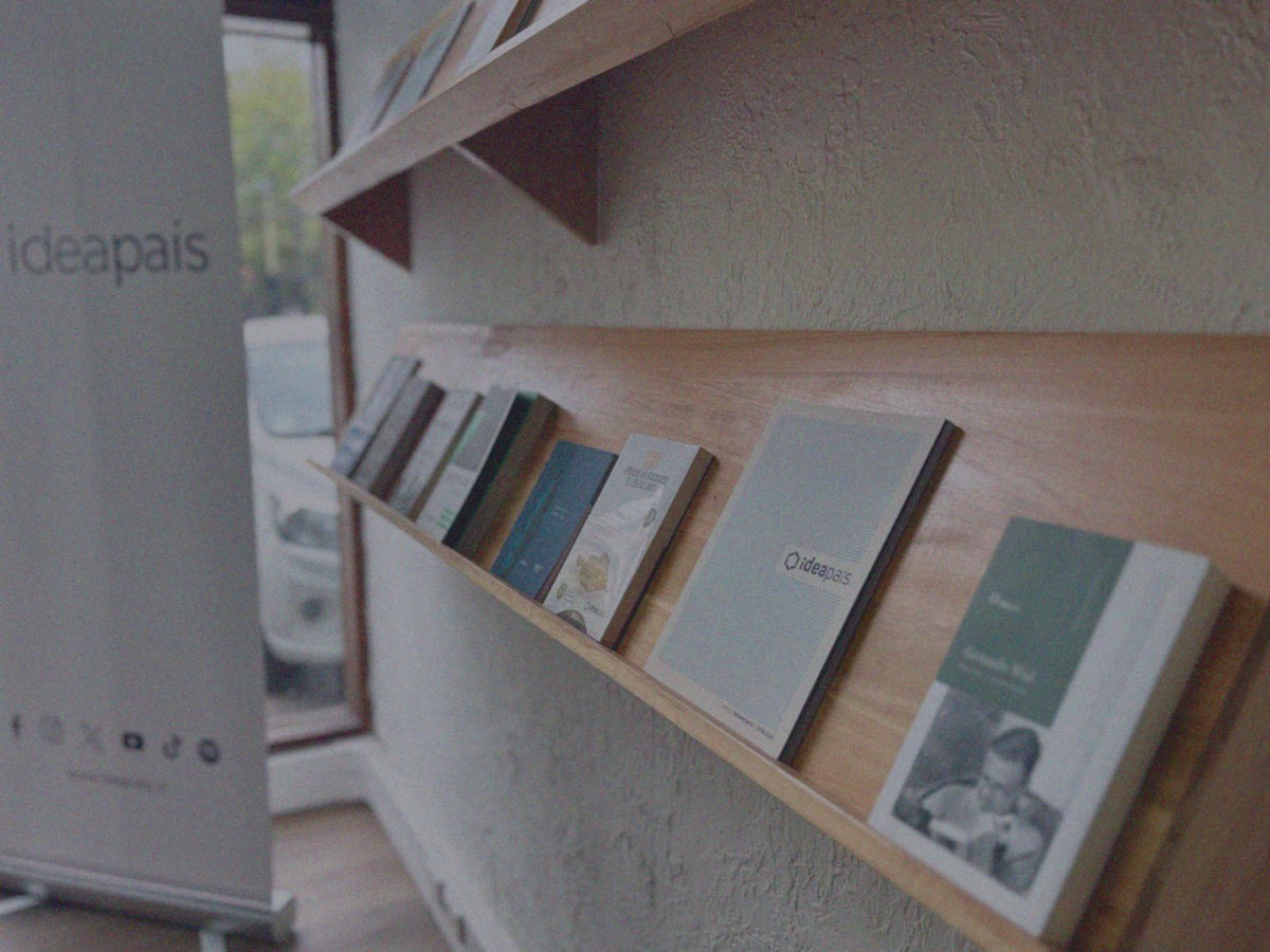 Libros y revistas expuestos en repisas de madera en la oficina de IdeaPaís.