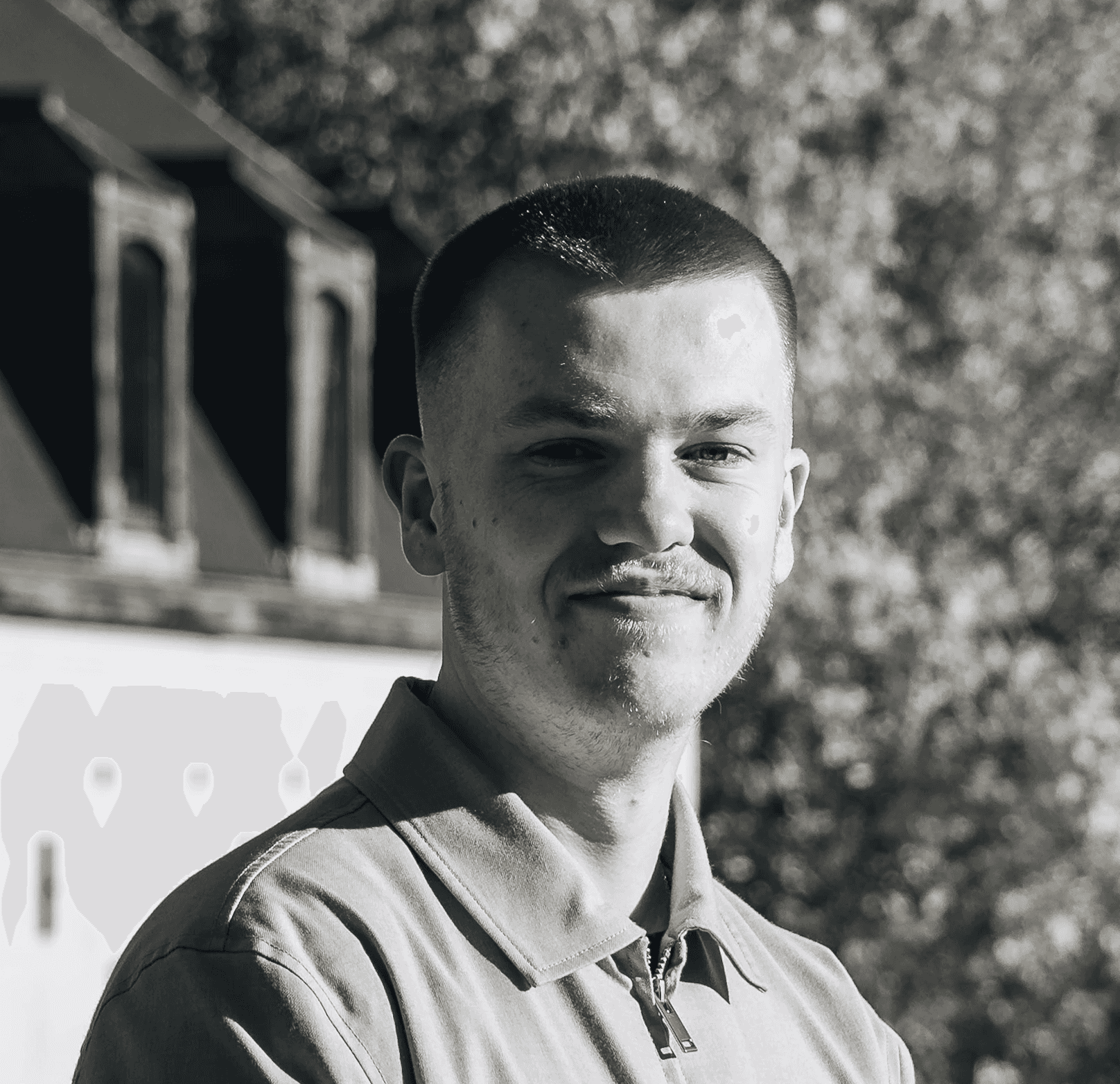 Portrait of a laughing person with curly hair wearing a white shirt