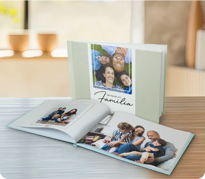 Pessoa segurando fotolivro com foto de mulher sorrindo ao ar livre, com a frase “Eu amo o Norte” escrita no canto da imagem