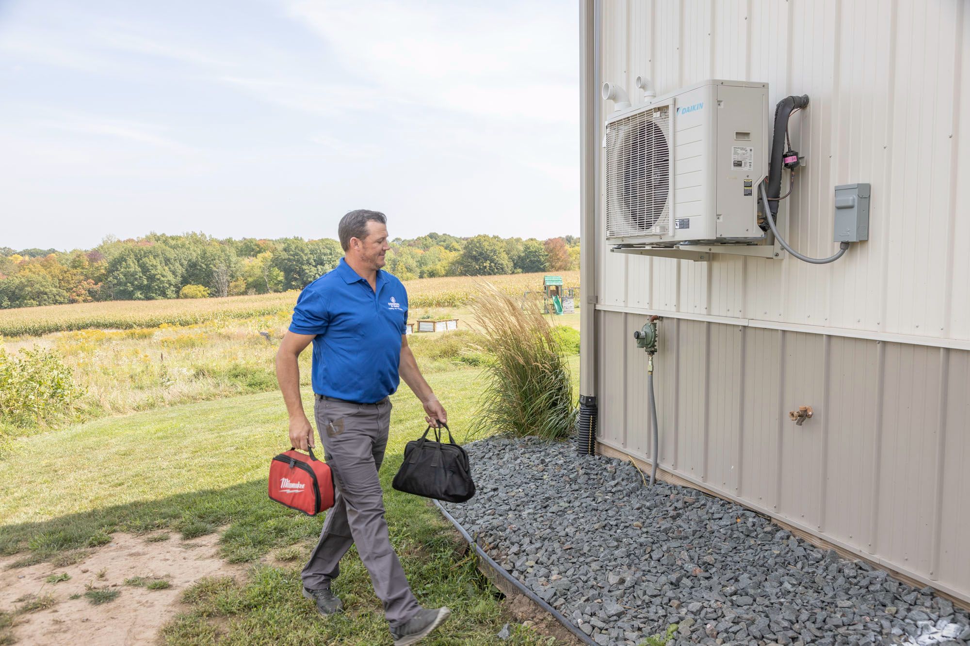 HVAC technician repairing outdoor air conditioning unit at residential home