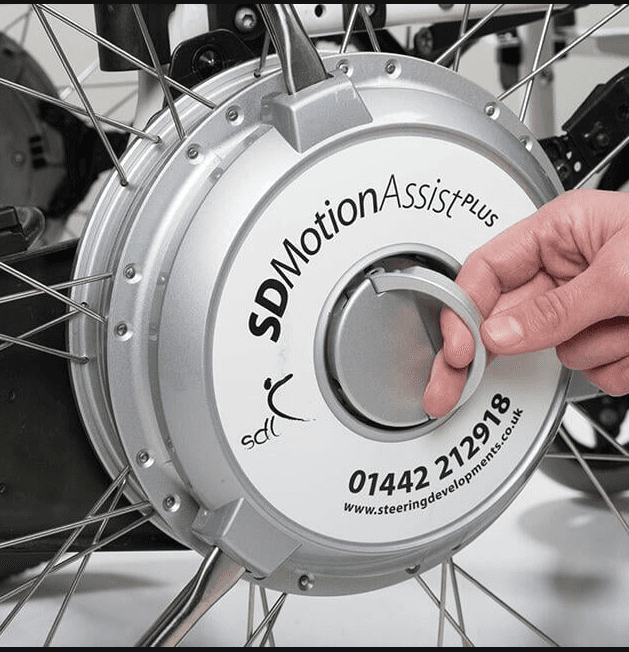 Close up of SD Motion Asssit wheel. Hand holding the D ring to release the wheels