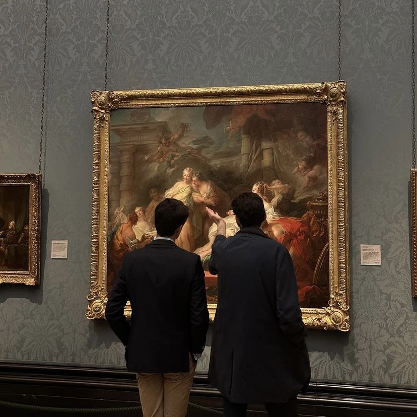 Dos personas analizando una obra de arte en un museo, representando la evaluación de estrategias publicitarias
