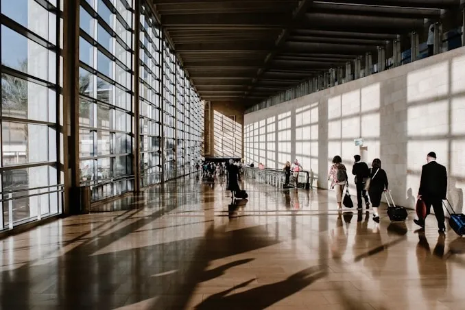 Professionnels traversant un terminal d’aéroport moderne.
