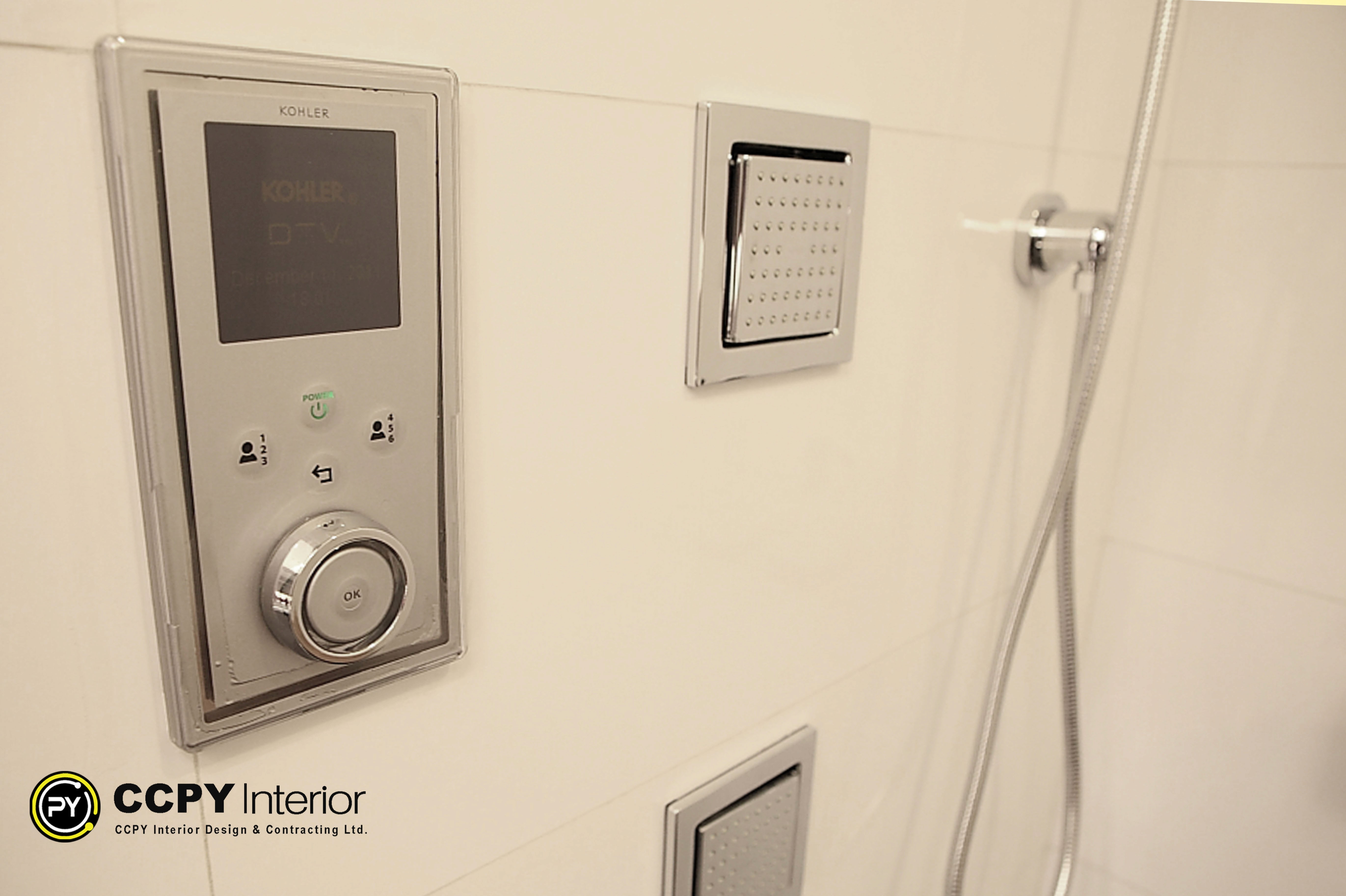 Close-up of a Kohler DTV digital shower control panel mounted on white ceramic tiles in a Standalone House, Perkins Road spa.