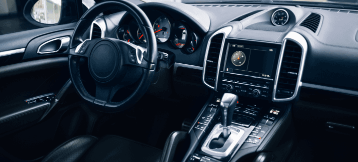 Photo of the interior dashboard and front seat area of a luxury automobile with dark colored appoint