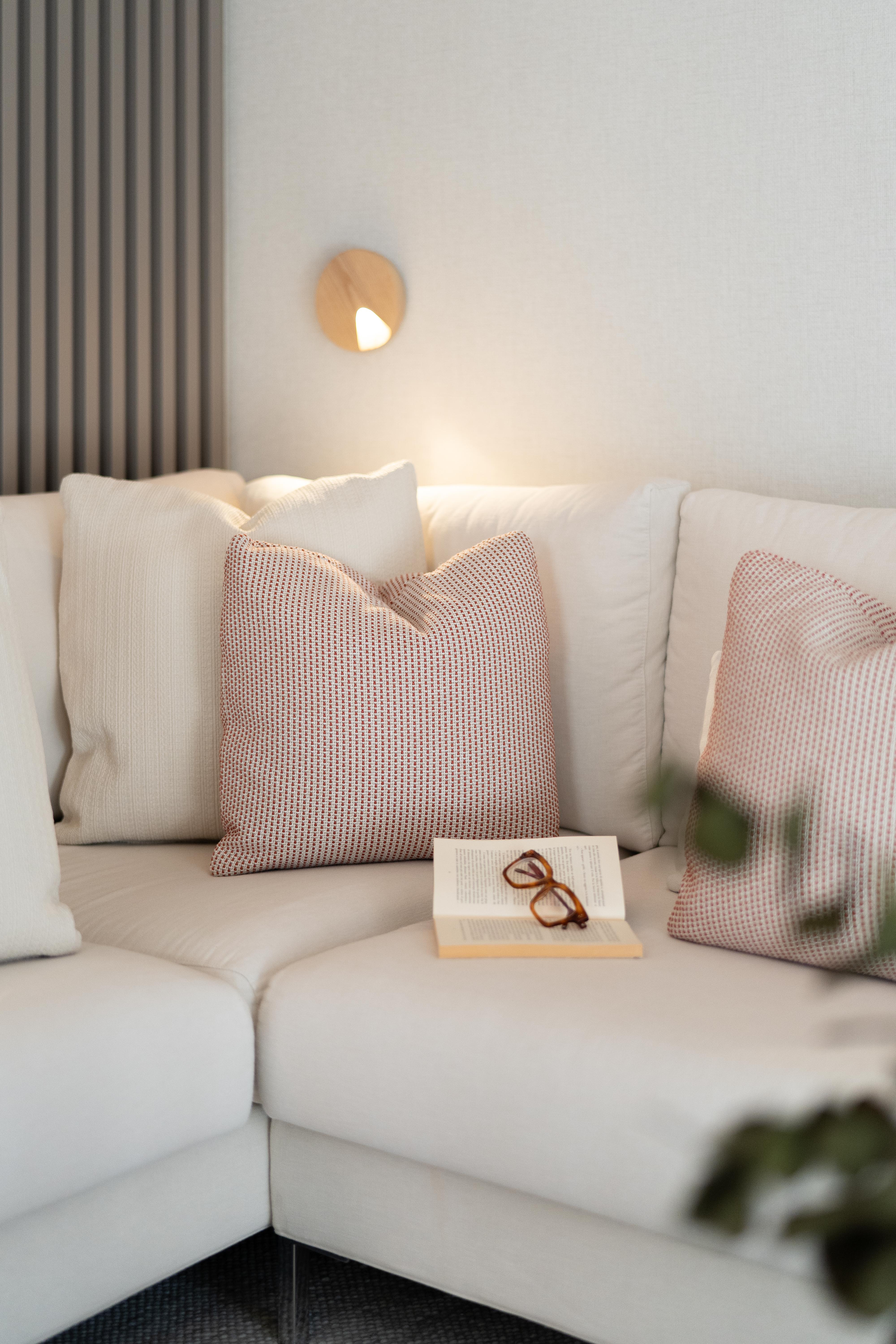 Sofá blanco con cojines decorativos rojos