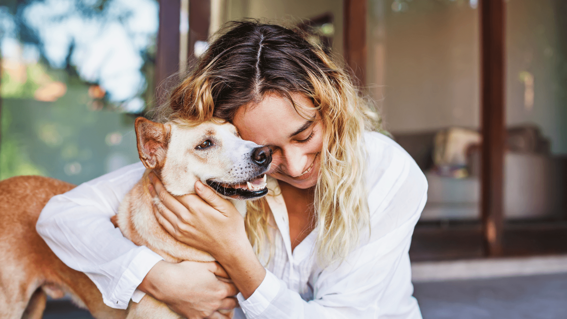 Woman hugging her dog after being reunited with him thanks to his microchip.
