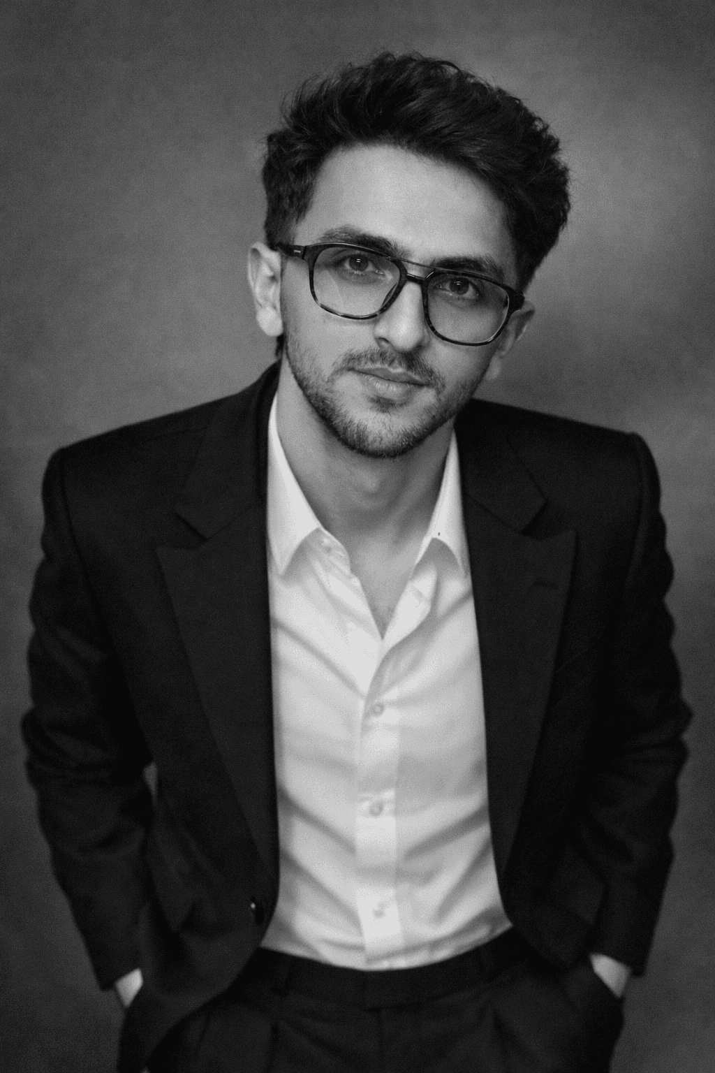 Young woman in a white shirt with a colorful gradient print, against a plain background.