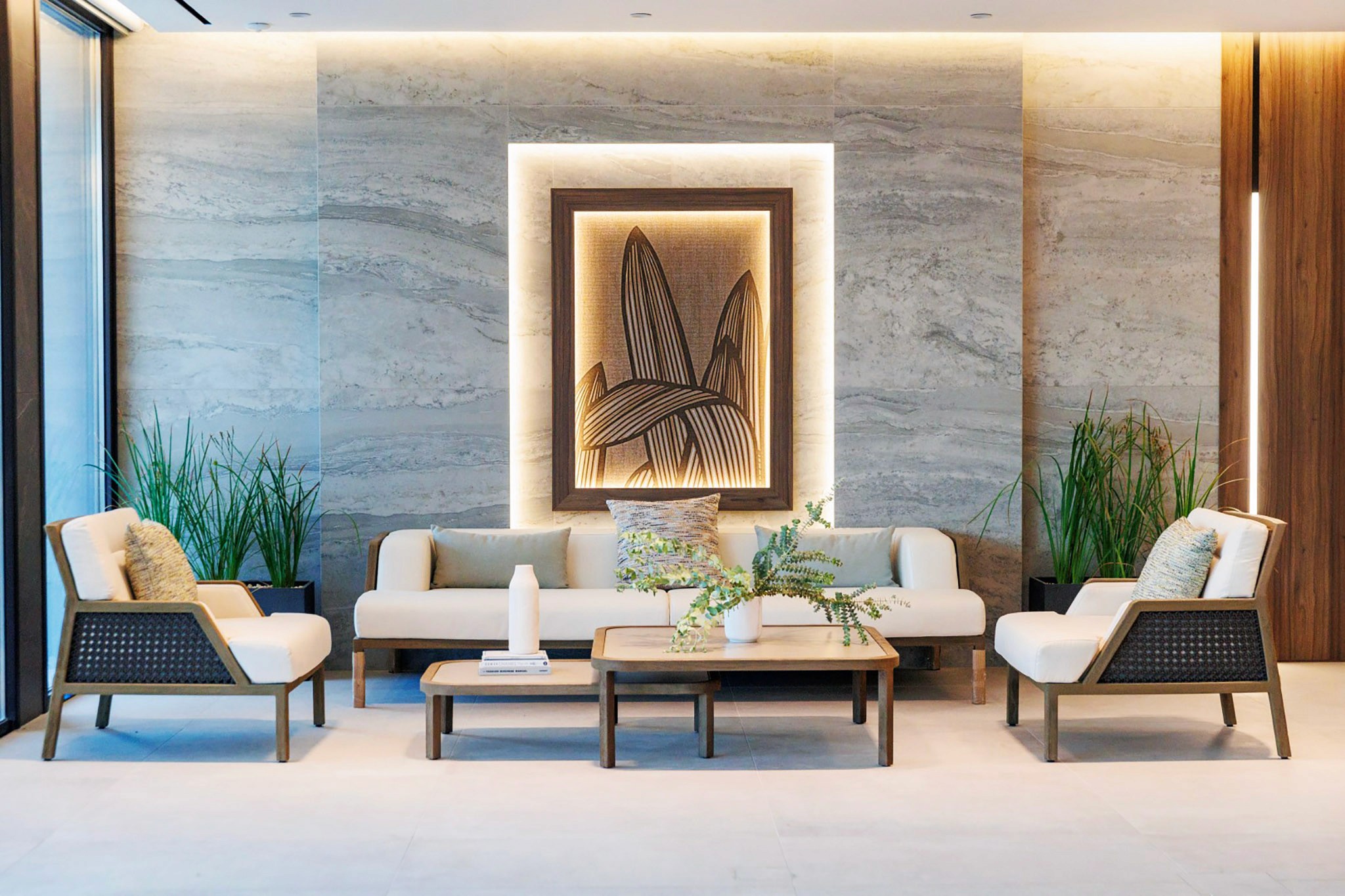 Villa Trio outdoor lounge with stone feature wall, framed artwork, and modern seating arrangement