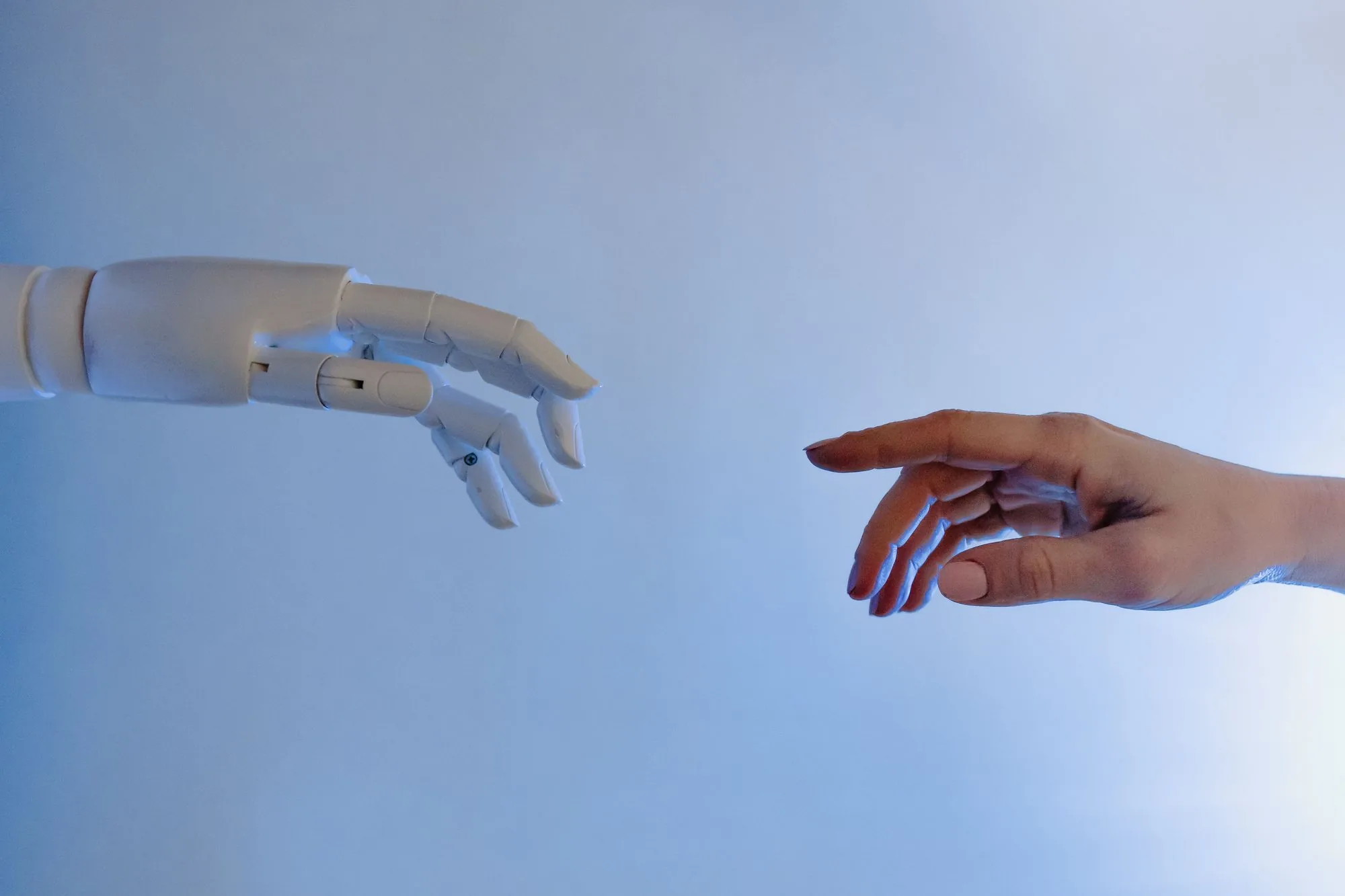 Human hand and robotic hand reaching towards each other