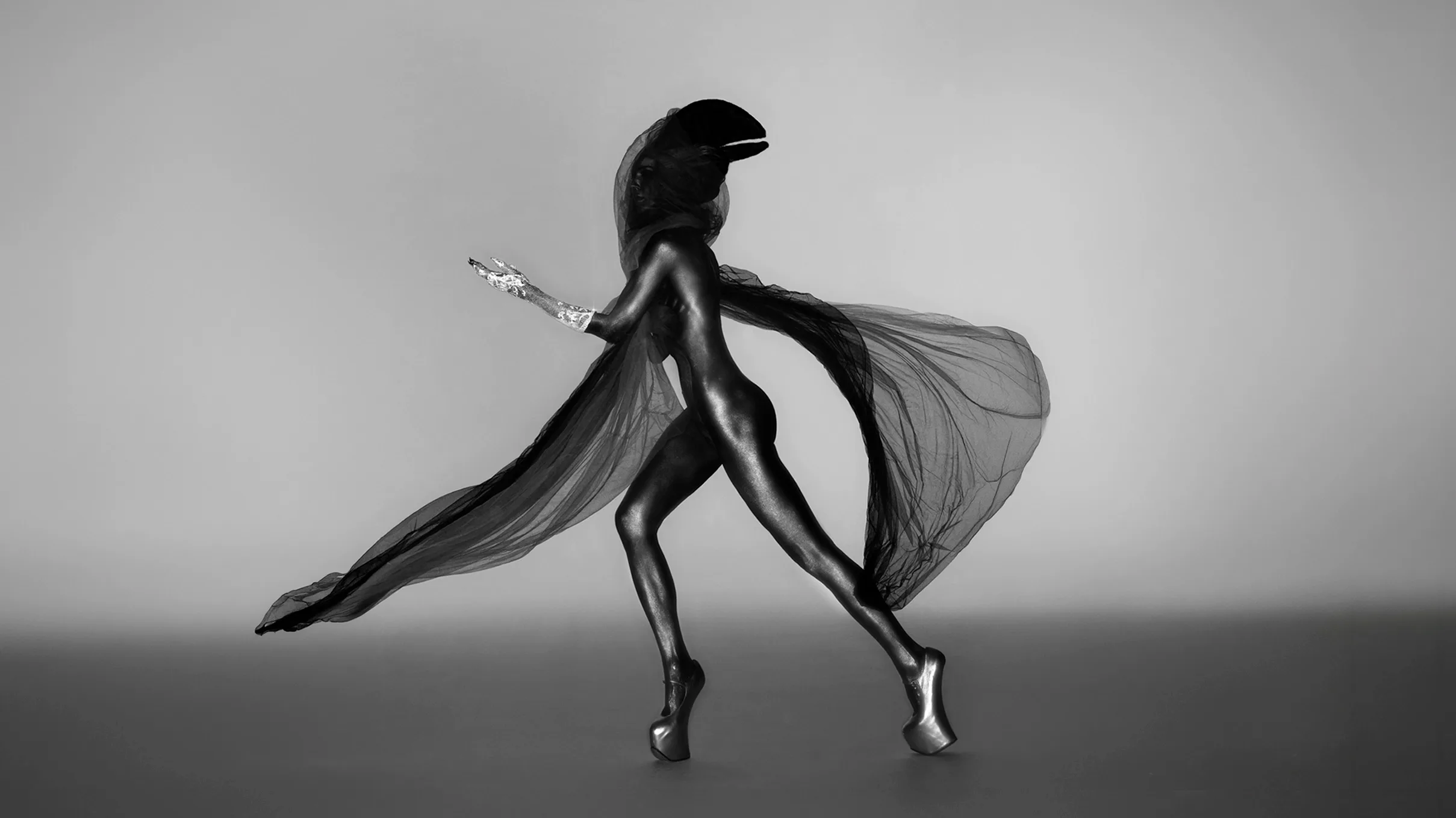 Black and white studio portrait of Daphne Guinness in full body paint, wearing the diamond-encrusted silver glove "Contra Mundum" designed by master jeweller Shaun Leane.