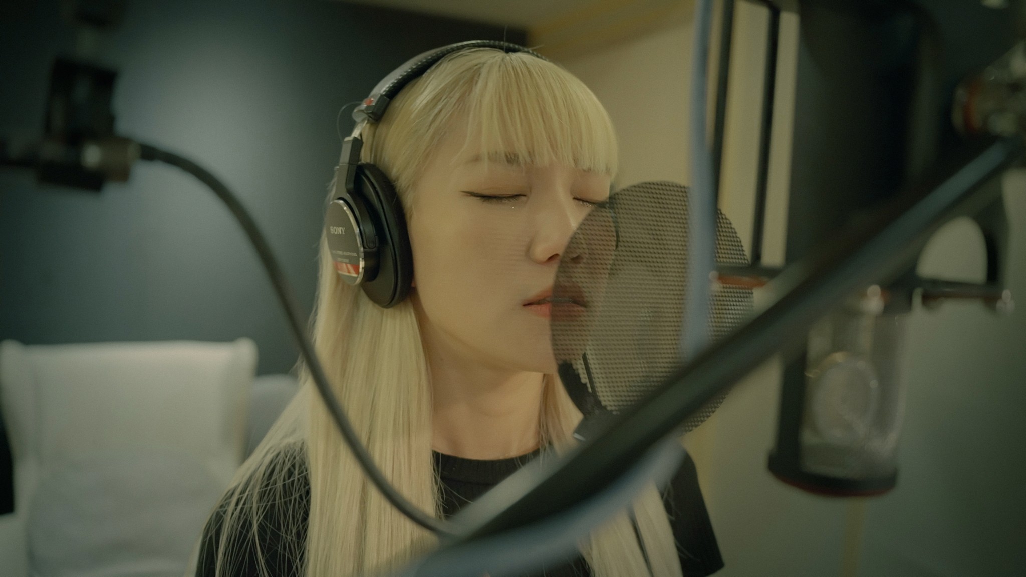 Film clapperboard in focus with glowing orange background, misty street, and silhouettes of people and lights; conveys mystery and anticipation.