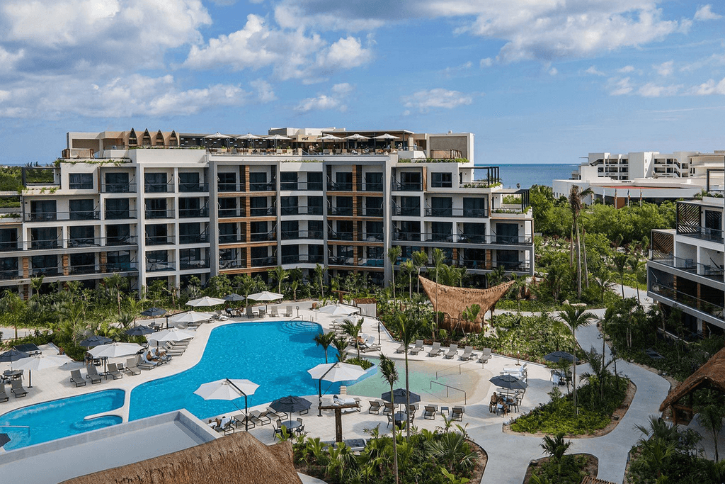 Couple standing on a balcony with binoculars in hand looking out over the ocean
