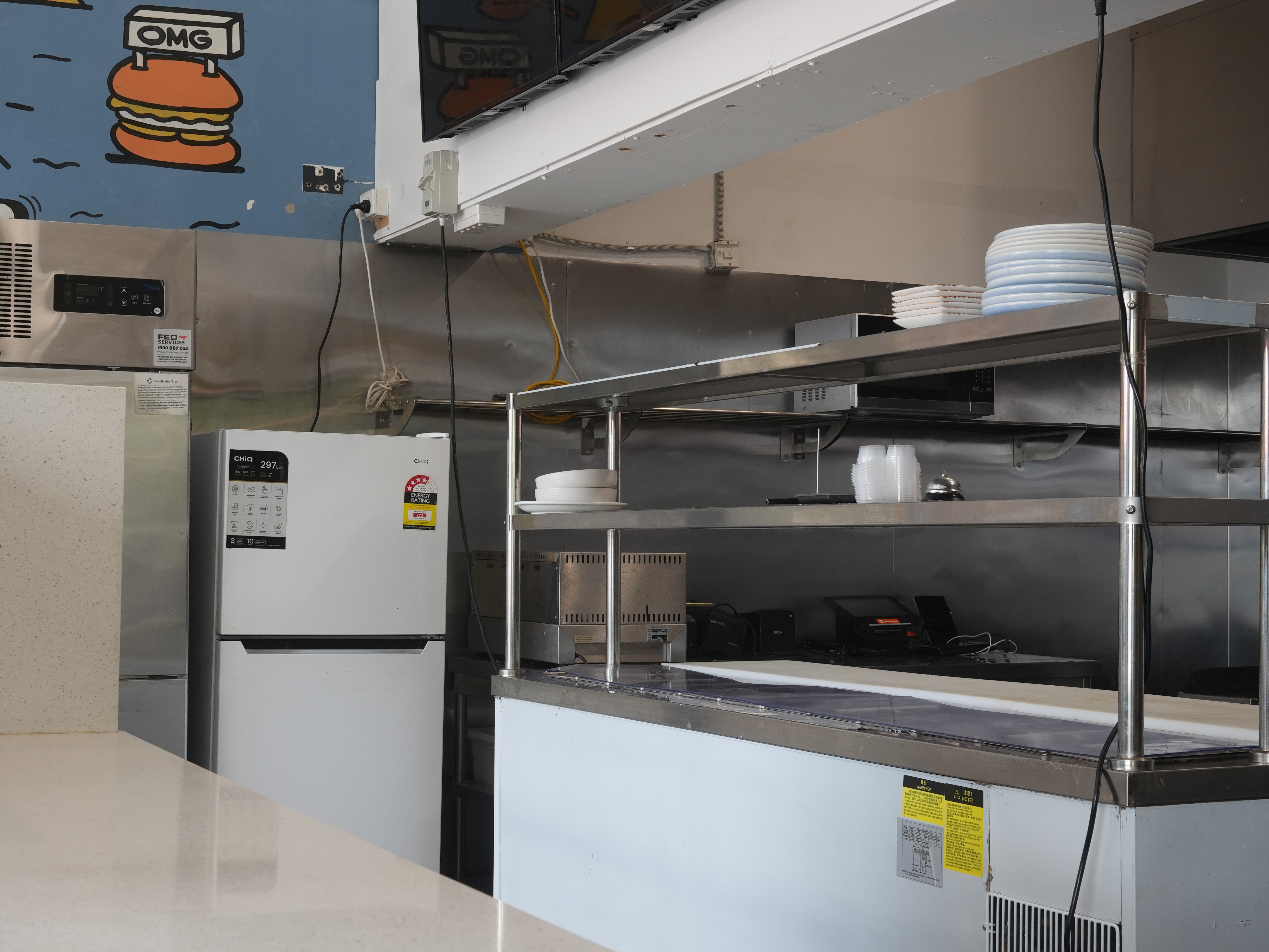 Hospitality fit-out for Heyburg in Coburg, Victoria with neon Hey'Burg signage, terrazzo counter, custom pop-art murals, brass pedestal tables, pendant lighting.