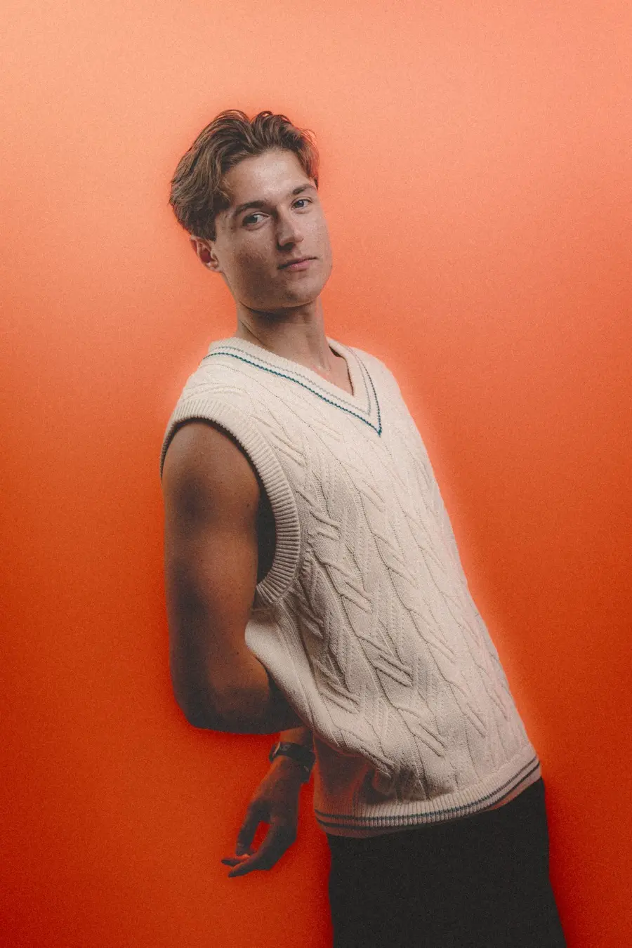 Foto van manlijk model in de studio met orangje achtergrond