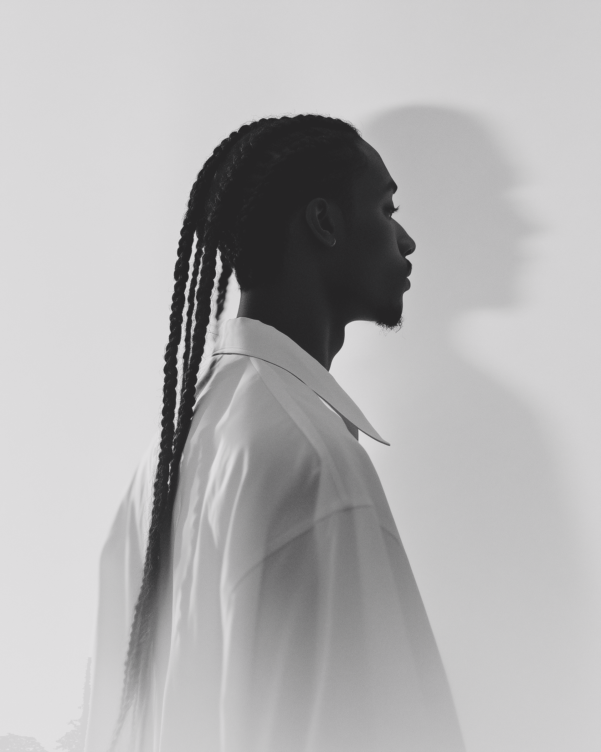 Dynamic Black-and-White Portrait Monochromatic profile of a man with long braids and a white shirt
