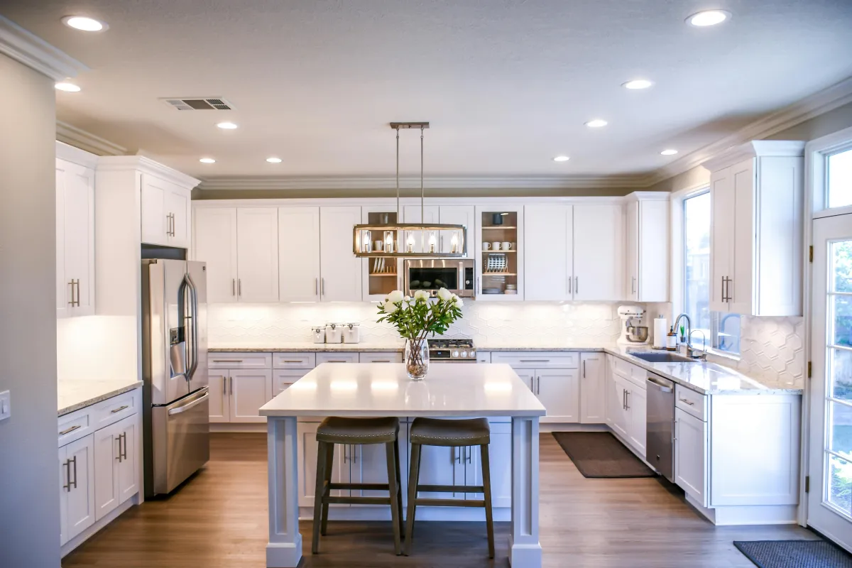 Bright kitchen with white cabinets and an island, representing selling a house for cash