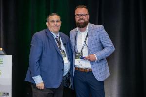 Brennan Summers accepting the NEACH President's Award on behalf of Stukent, Inc.