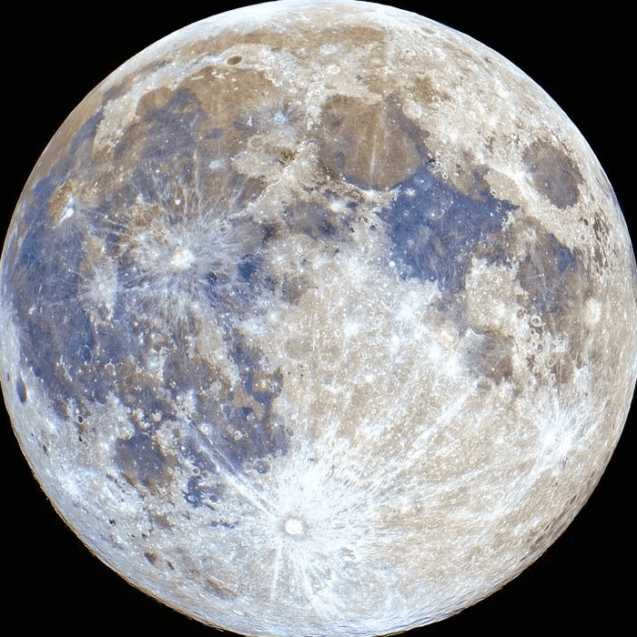 A close-up of a hand wearing multiple decorative rings against a blue background.