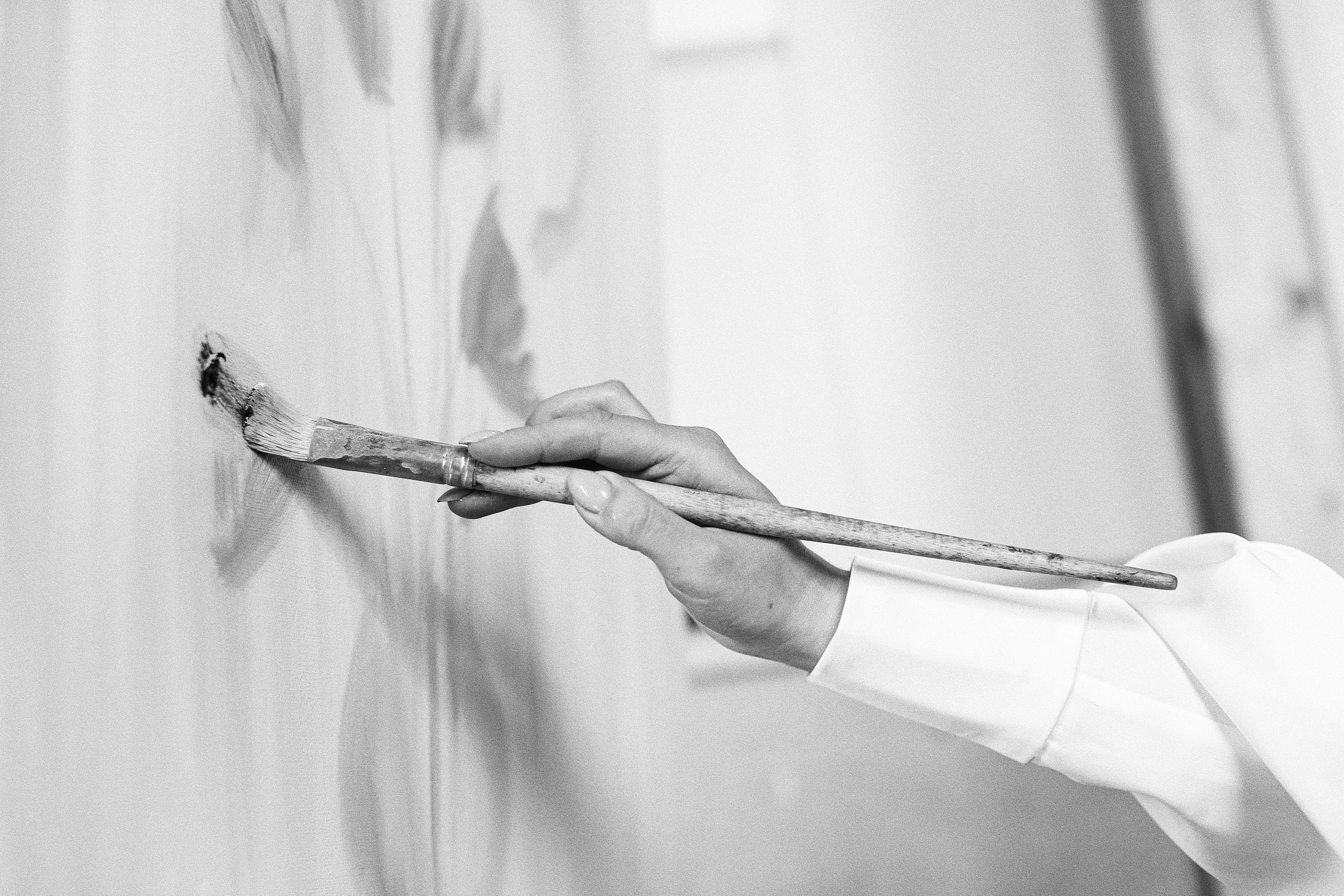 Black and white photograph of an artist painting, used as the header image for the Skarlett Stardust brand and website design.