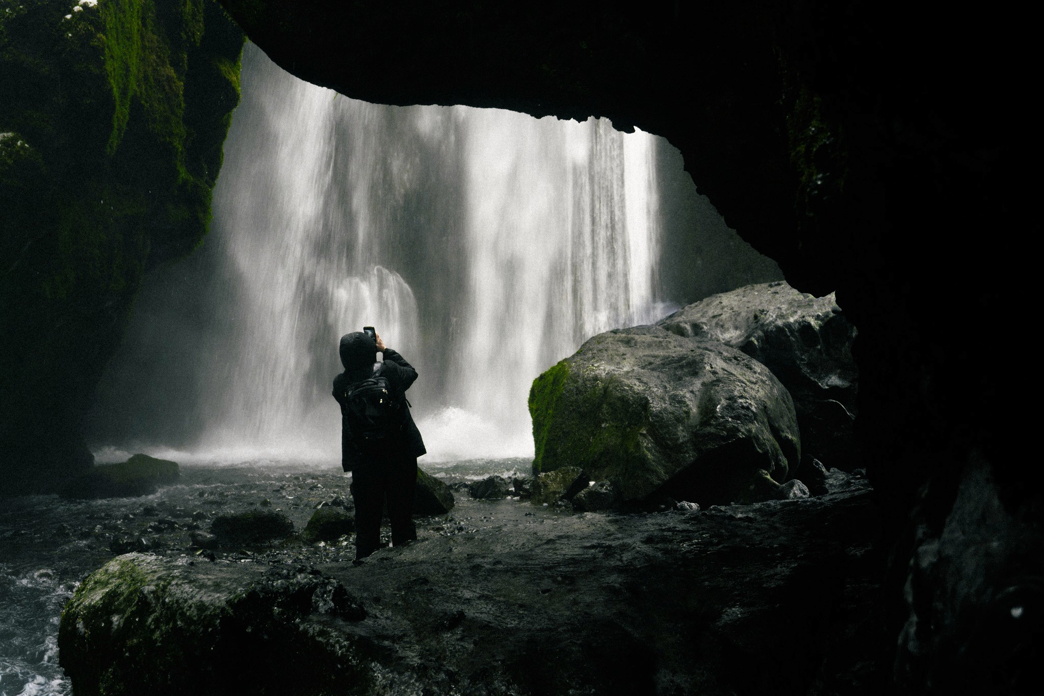 A close-up of a hand wearing multiple decorative rings against a blue background.