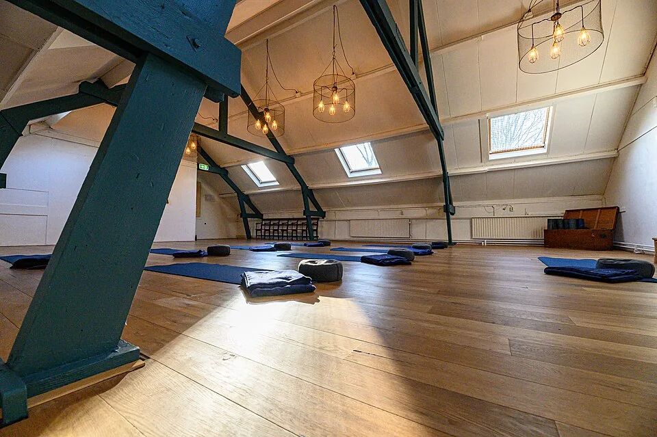 A bright yoga studio with mats arranged for a class.