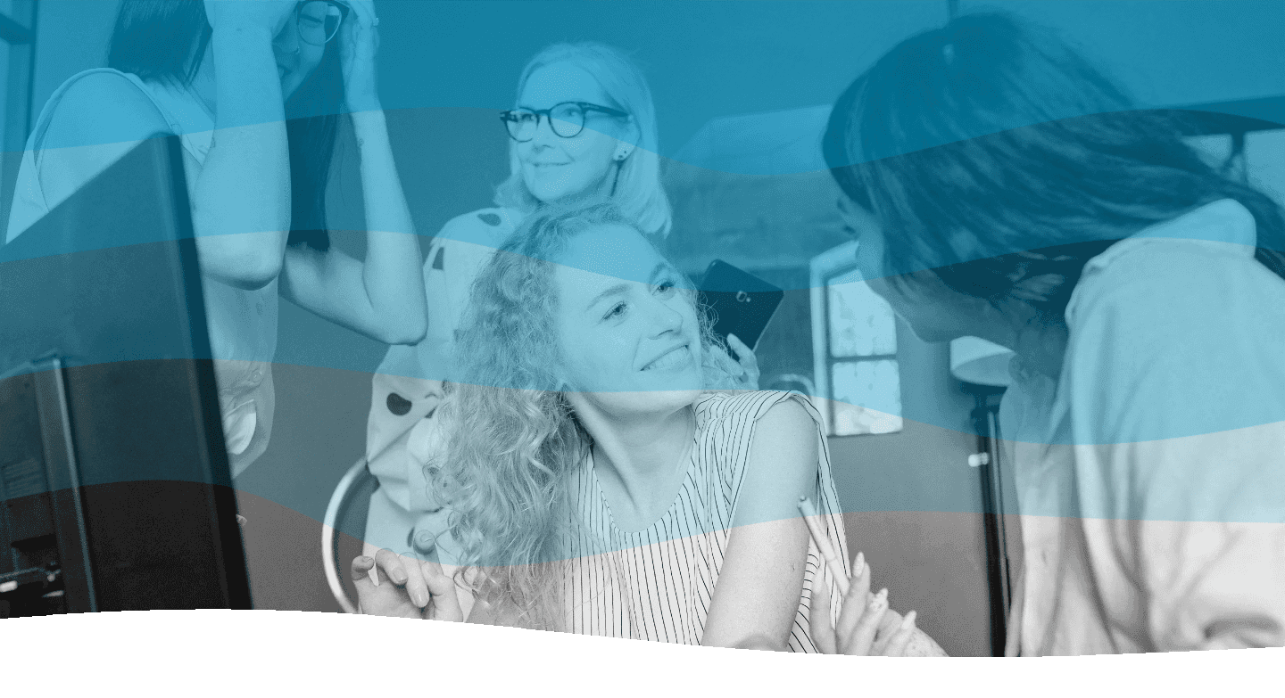 Four people gather around a computer, engaging in a lively discussion, with the image overlayed by a blue, wavy design.