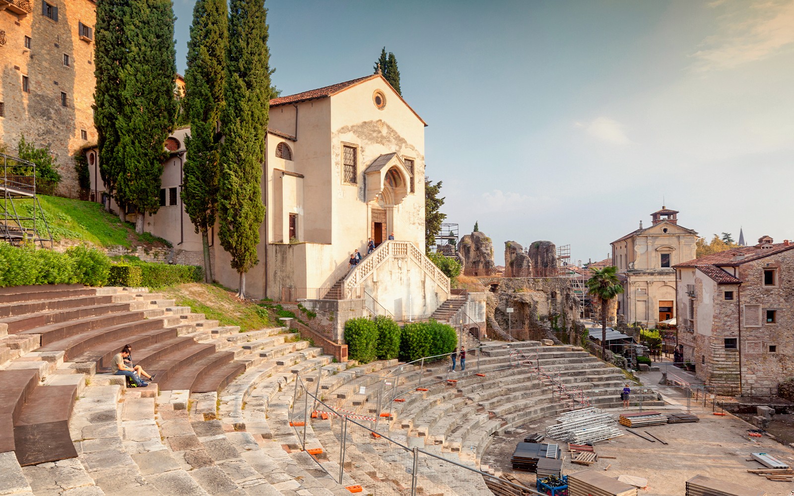 Teatro Romano Verona dengan tempat duduk batu purba dan bangunan bersejarah berhampiran.