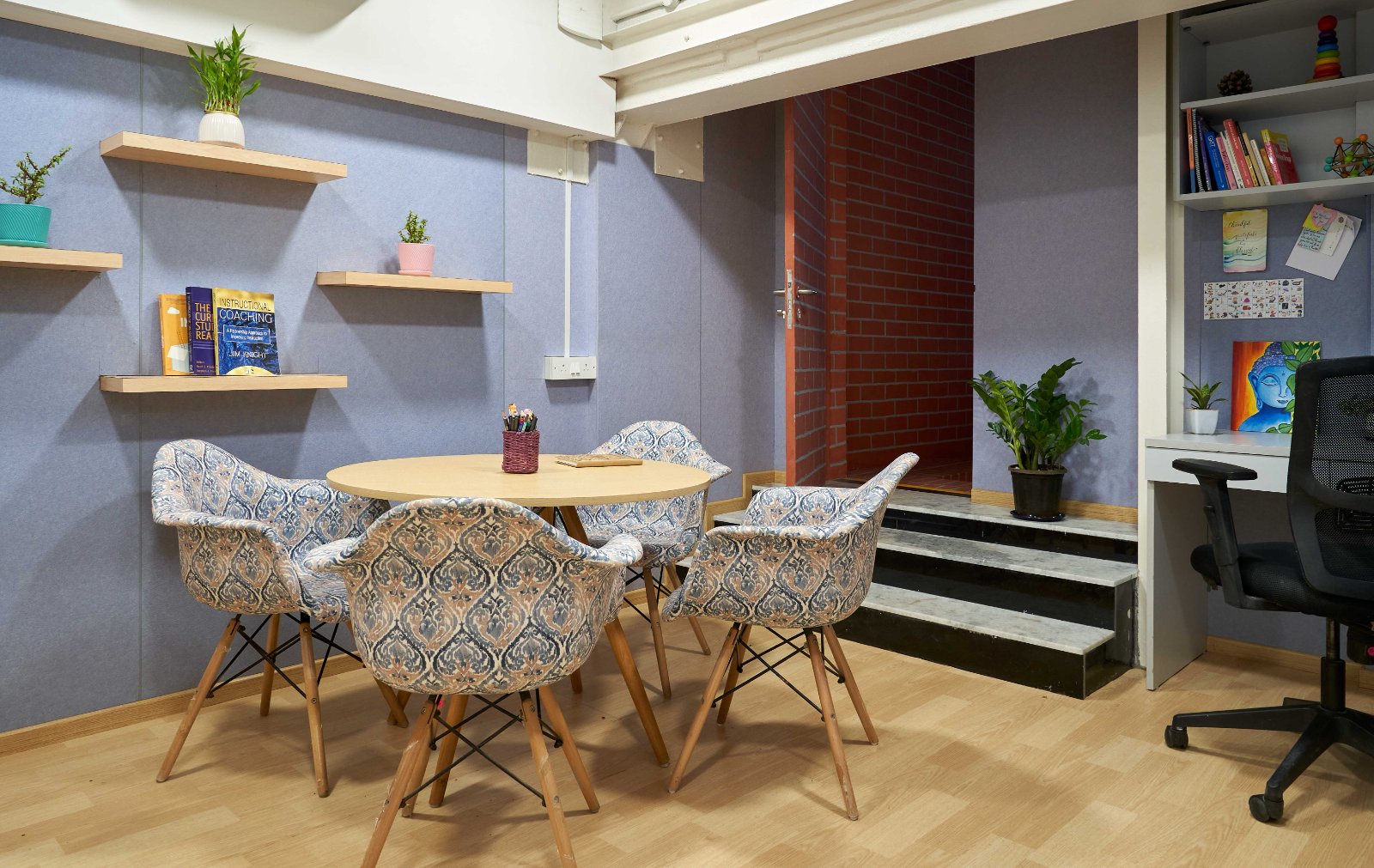 Nature-inspired preschool entrance with sculptural tree partitions and suspended green leaf ceiling panels.