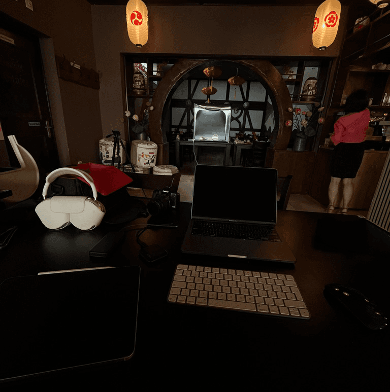 dunkler Restaurant Innenraum mit Photobox am Ende des Bildes für ein Fotoshooting mit Arbeitslaptop im Vordergrund