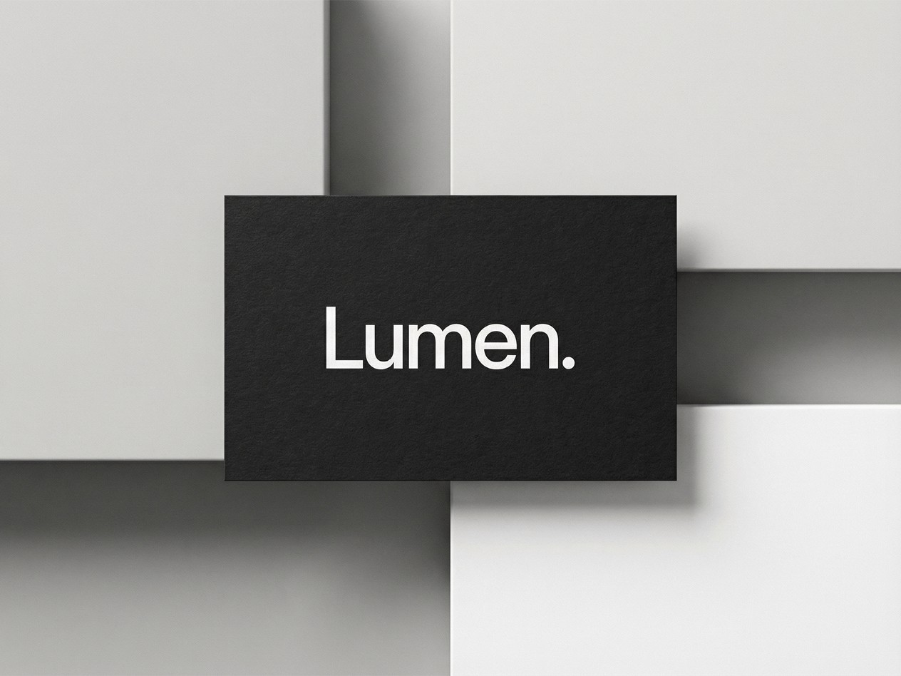 Black textured business card featuring the Lumen logo on a minimalist geometric background