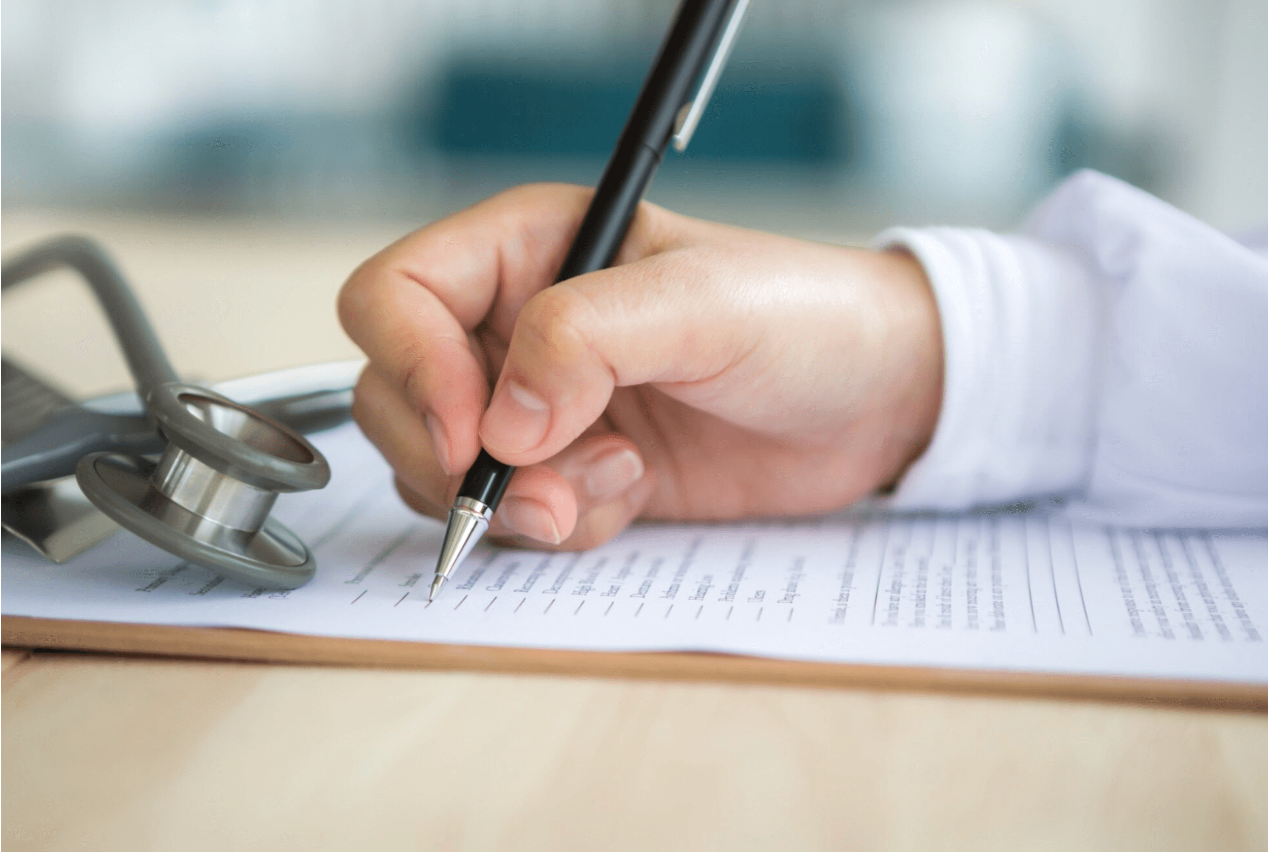 Hand with pen filling out a document. Courtesy of Pexels