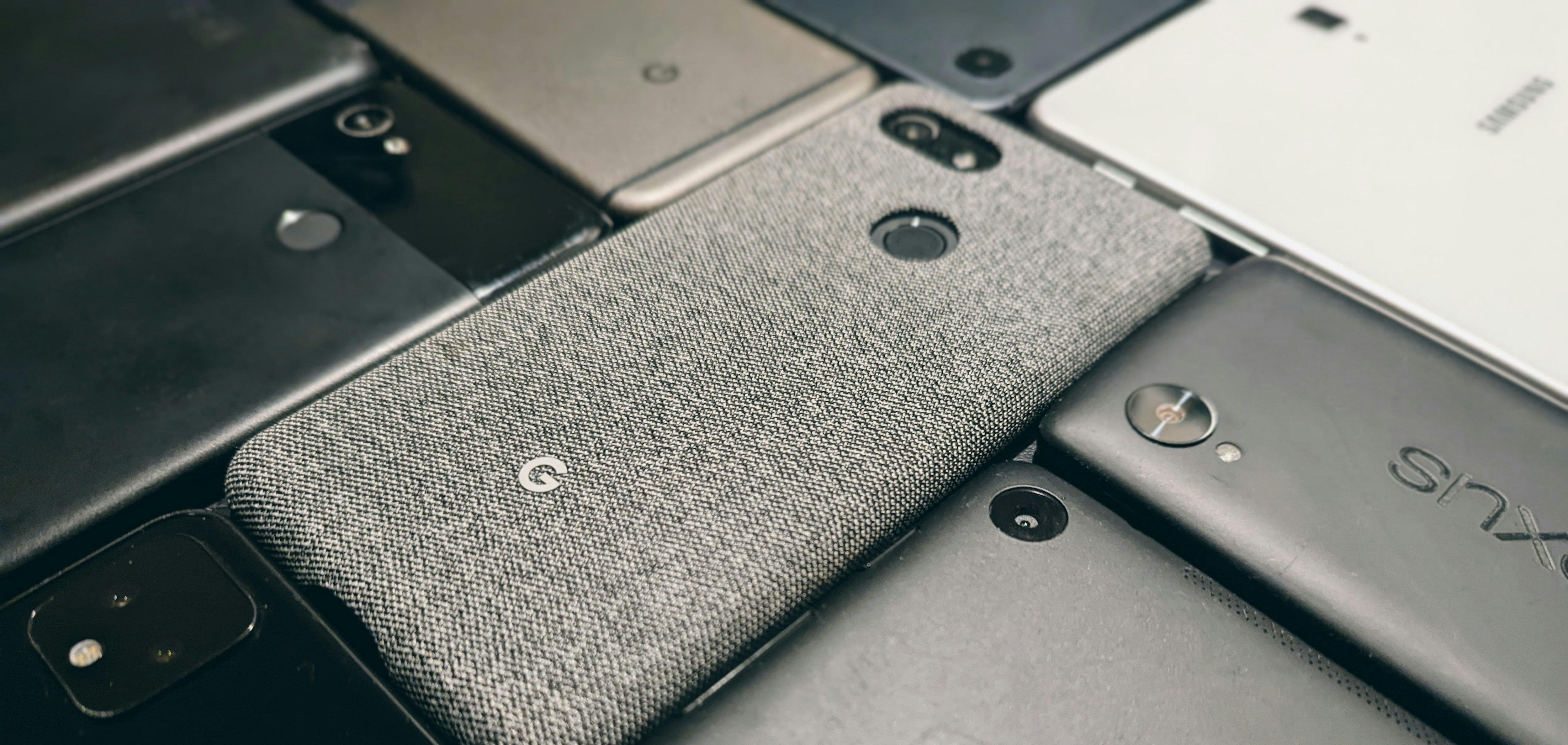 a pile of different cell phones sitting next to each other