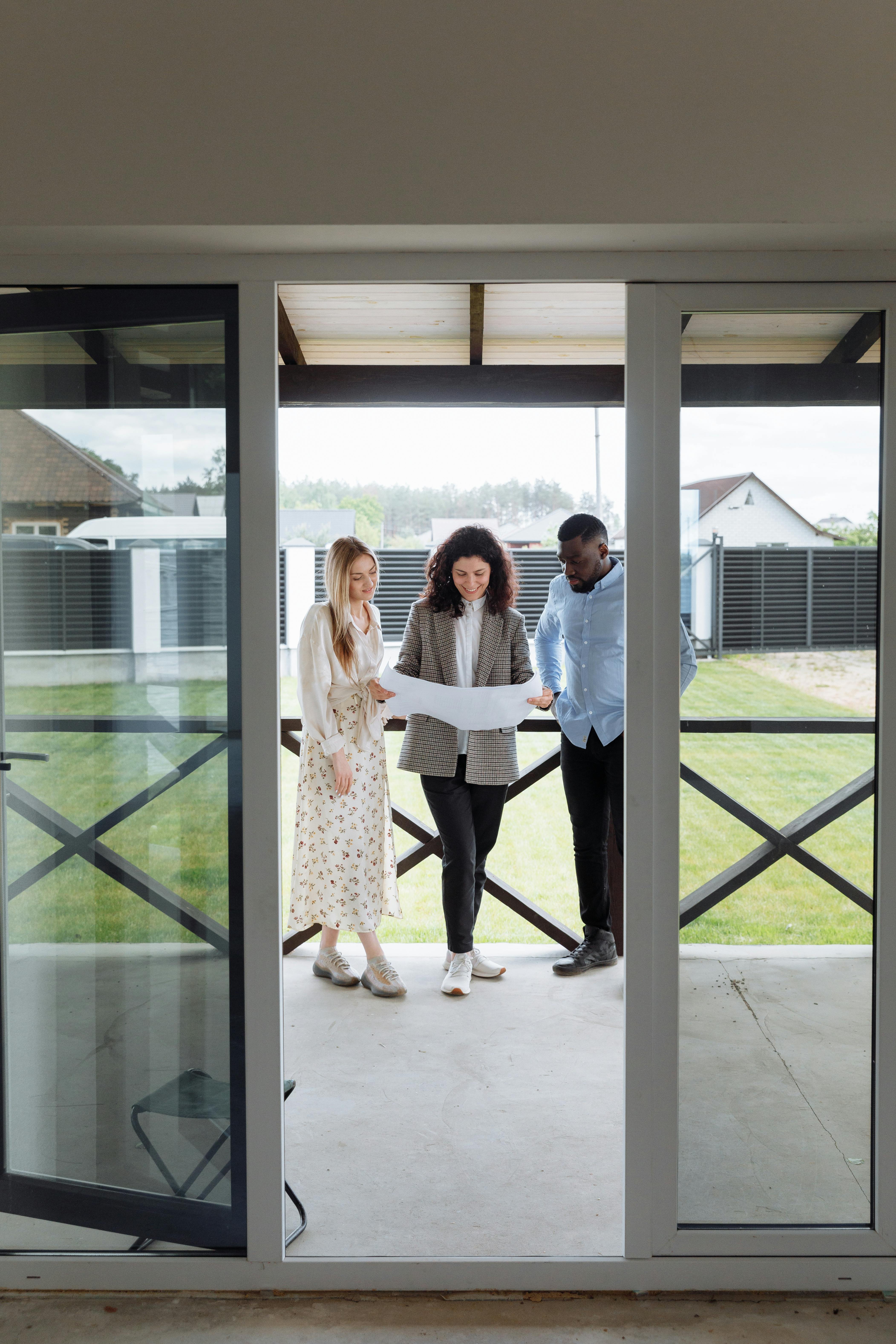 Couple with a real estate agent showing them around a property