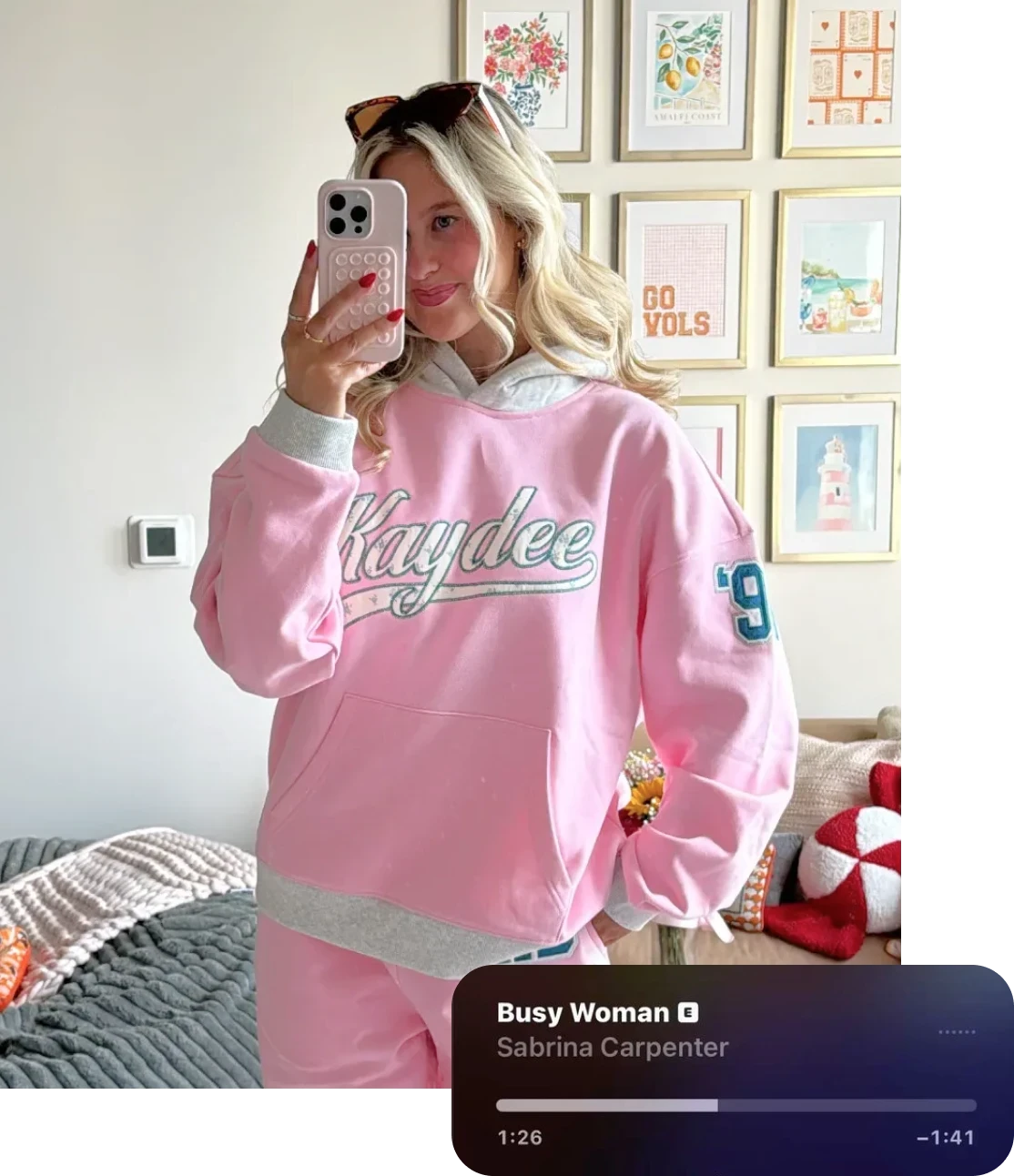 Mirror selfie of a person wearing a pink “Kaydee” hoodie with matching sweatpants in a bedroom.